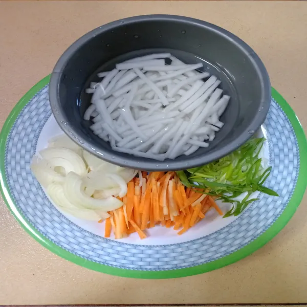 Potong bawang bombai, wortel, dan daun bawang menyerong agar panjang.