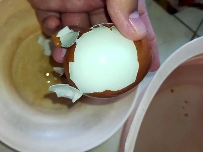 Tarik kulit telur yang melekat dengan cangkang. Kupas hingga tidak ada kulit telur yang menempel.