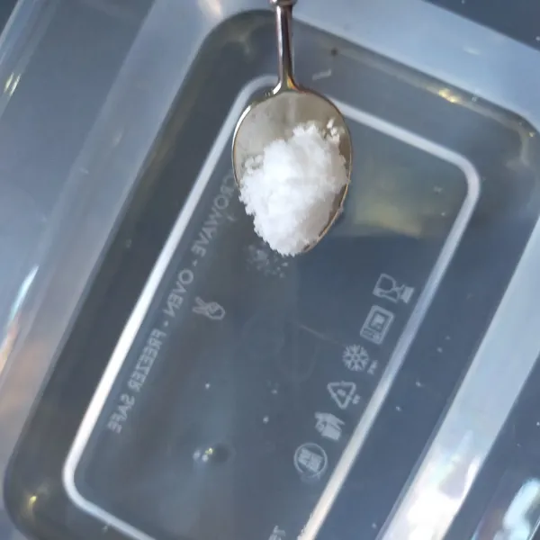 Siapkan wadah plastik berisi air lalu beri dengan 1/2 sdt garam. Aduk hingga garam larut.