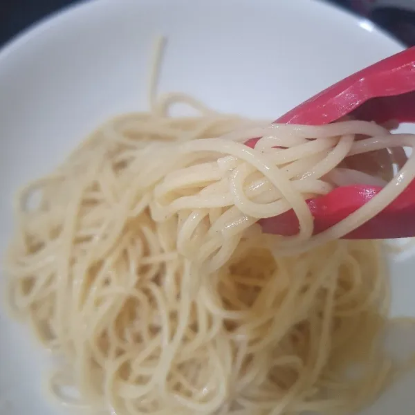 Tiriskan spaghetti, siram dengan air matang mengalir untuk menghentikan proses pemasakan.