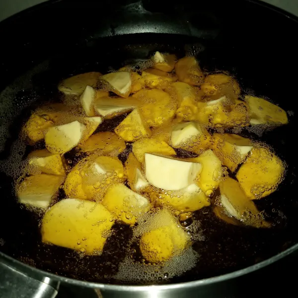 Panaskan minyak banyak dengan api sedang. Goreng ubi sampai matang, empuk, dan bagian luarnya berkulit.
