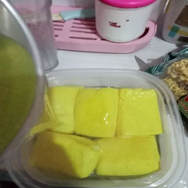 Taruh tahu di wadah kedap udara, masukkan beserta air rebusan sampai tahu terendam, tutup rapat.