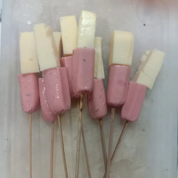 Sambil menunggu adonan mengembang, tusuk sosis dan mozarela ke tusukkan sate