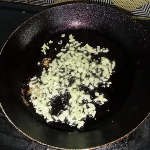 Tumis bawang putih hingga harum dan kekuningan.