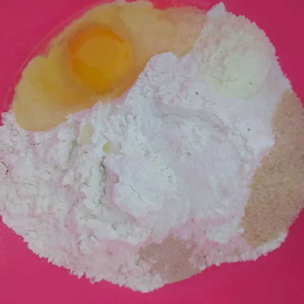 Campurkan margarin yang telah dilelehkan dan air kemudian aduk rata. Tuang kedalam bahan kering dan uleni hingga kalis elastis.