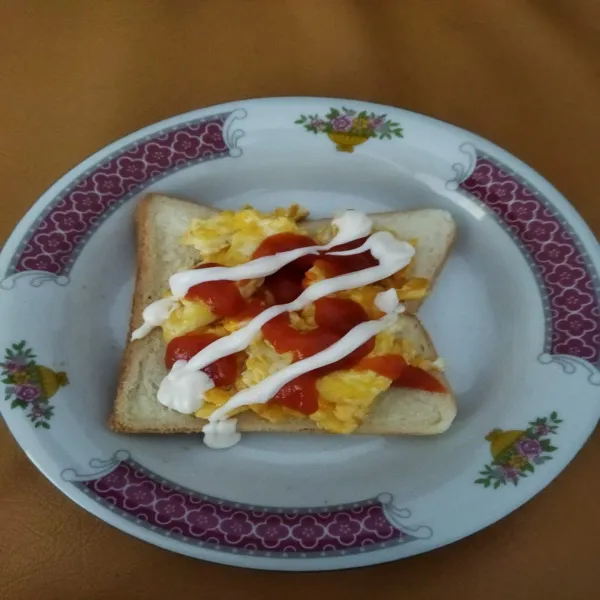 Beri mayonaise, kemudian tutup kembali dengan roti. Potong roti menyerong berbentuk segitiga, sandwich siap disajikan.