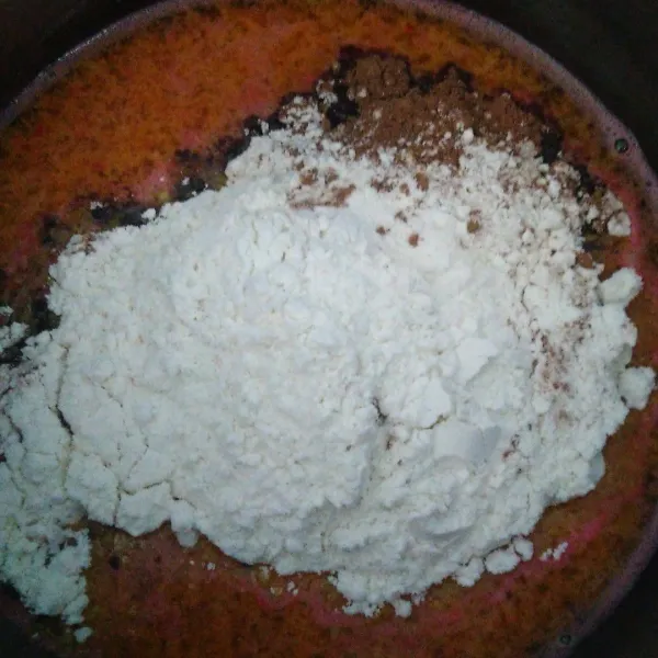 Masukkan tepung terigu dan coklat bubuk. Kemudian tambahkan 1 tetes pewarna makanan warna merah.