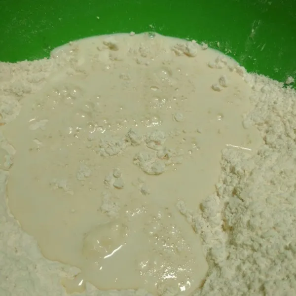 Dalam bowl campur tepung terigu, gula pasir halus tambahkan campuran susu dan ragi aduk hingga rata.