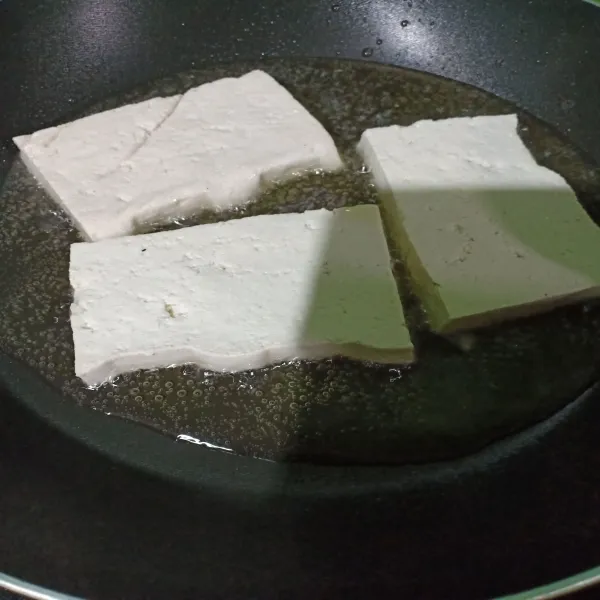 Goreng tahu sebentar dengan sedikit minyak. Jika bagian bawah sudah kering kemudian balik masak sisi lainnya.