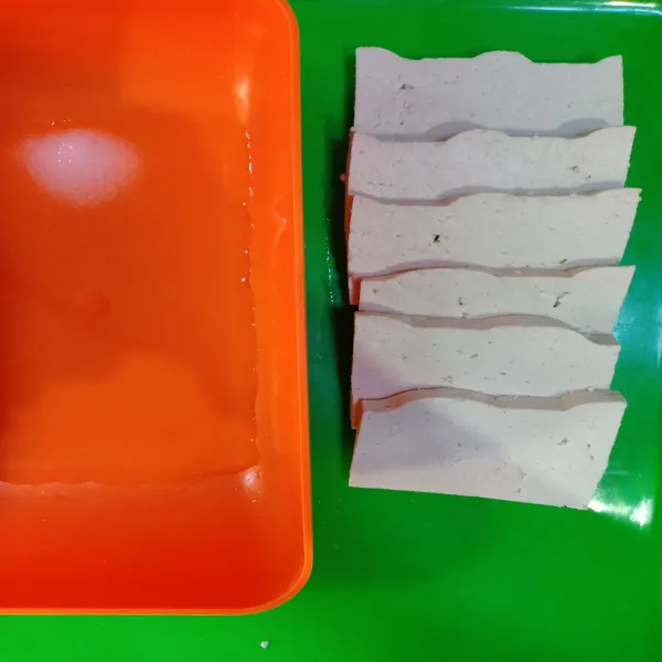 Potong tipis tahu lalu rendam di air garam