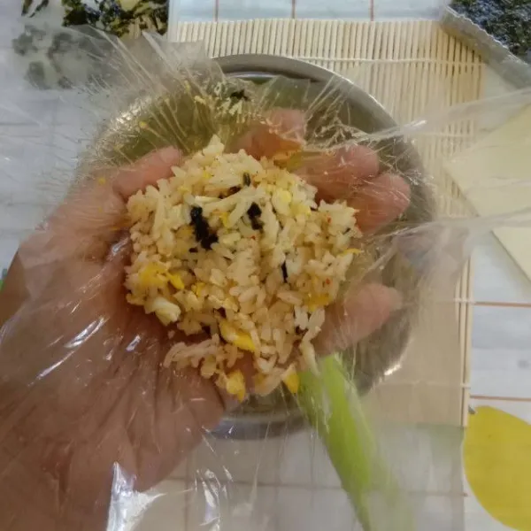 Siapkan 1 lembar plastik, ambil 2 sdm nasi (apabila punya cetakan nasi bulat lebih mudah ya).