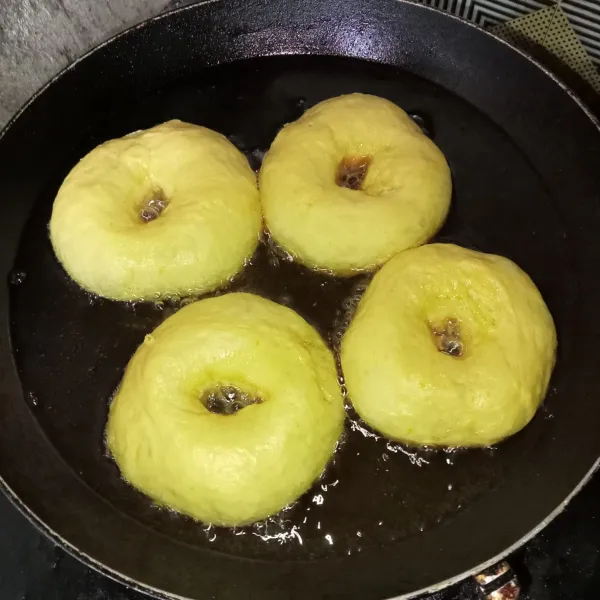 Lubangi adonan dengan jari, lalu goreng dengan api kecil hingga matang, angkat dan tiriskan. Setelah dingin beri topping sesuai selera.