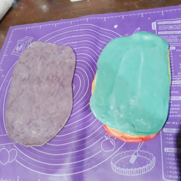 Kempiskan masing-masing adonan, giling tipis memanjang. Tumpuk setiap lapisan dan olesi susu uht diatasnya agar menempel.