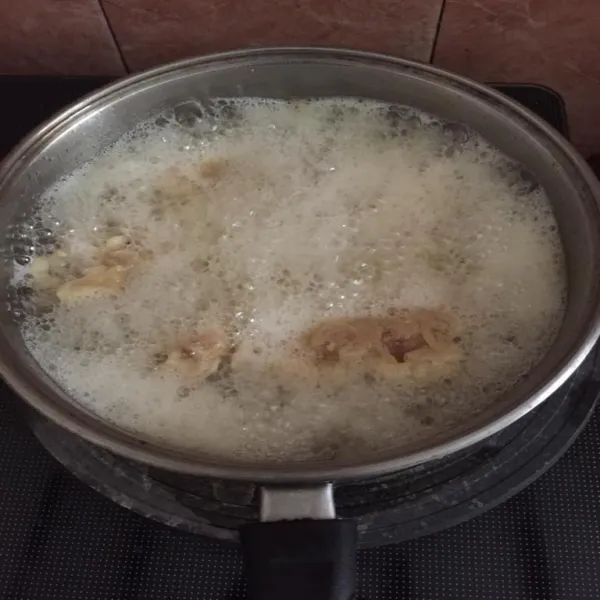Segera goreng ayam ke dalam minyak yang panas dan banyak sampai matang.
