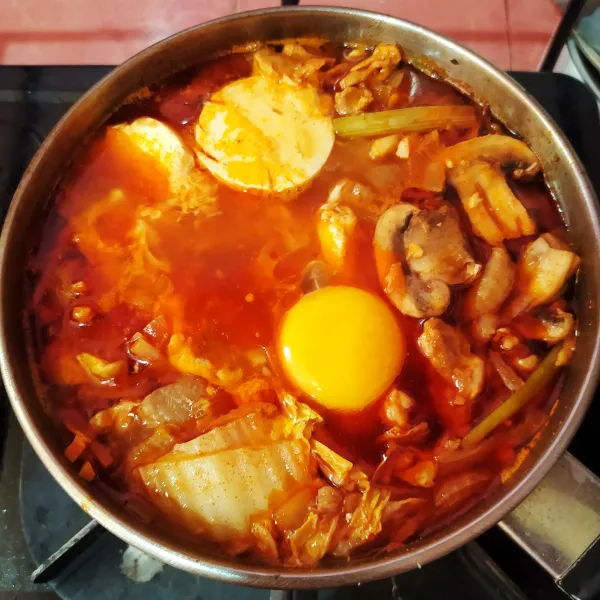 Setelah sayuran empuk, pecahkan telur tepat ditengah-tengah sup. Biarkan telur setengah matang, lalu angkat. Sajikan selagi panas.