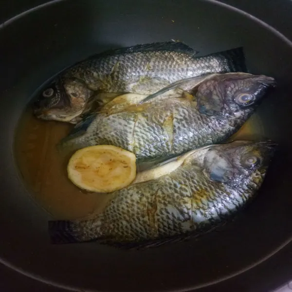 Cuci bersih ikan, masukkan perasan jeruk lemon, garam dan juga bumbu racik ikan goreng.