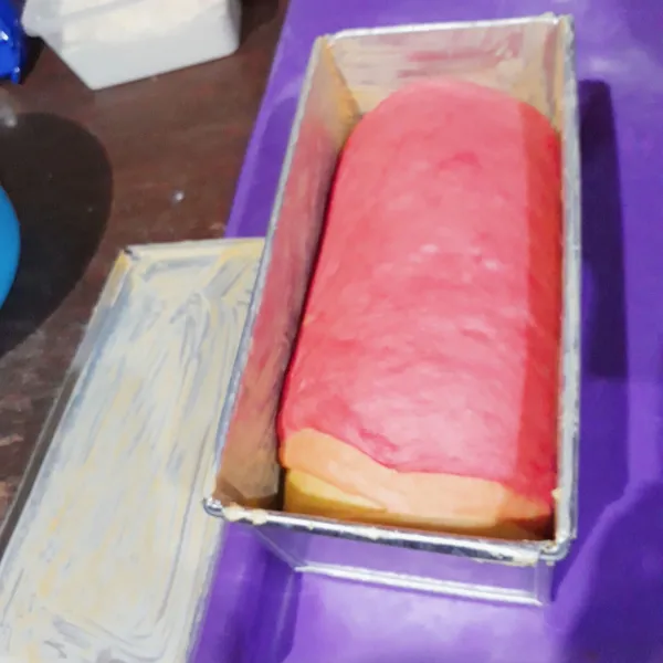 Olesi cetakan roti tawar ukuran 12x12x25 cm dengan mentega. Masukkan roti ke dalam cetakan, tutup cetakan, diamkan 30 menit.