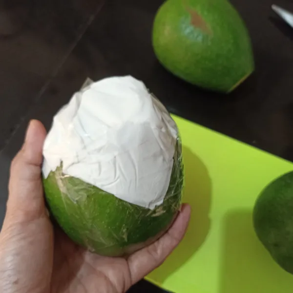 Lipat tisu menjadi 4 bagian, kemudian letakkan tisu di ujung buah alpukat yang sudah di potong tadi, kemudian lakban sekelilingnya hingga rapat.