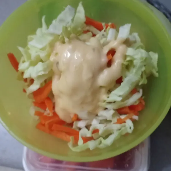 Iris kol dan wortel, tambahkan dressing salad, aduk rata.