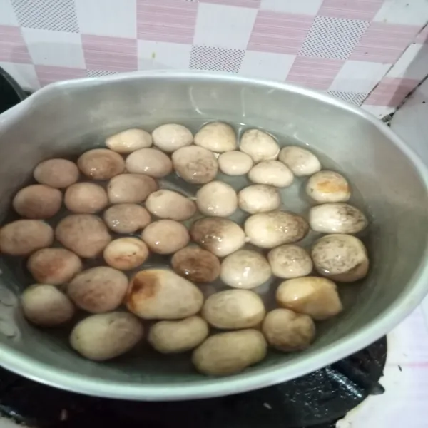Rebus air lalu beri garam, aduk rata. Rebus jamur hanya 1 menit, matikan api lalu buang airnya.