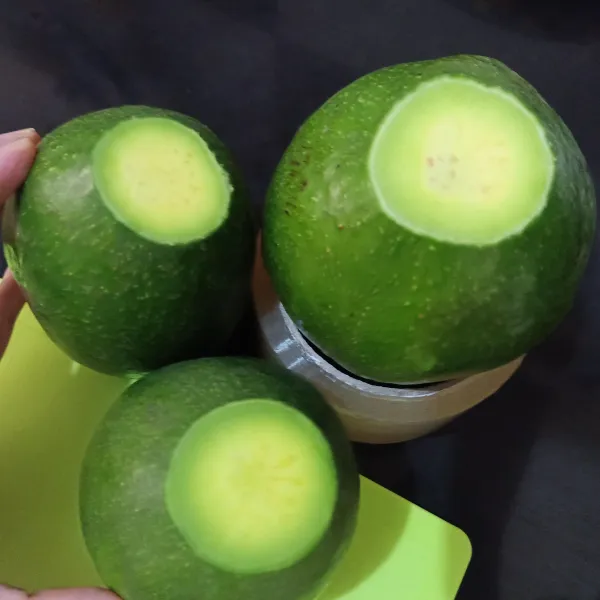 Potong ujung buah alpukat.