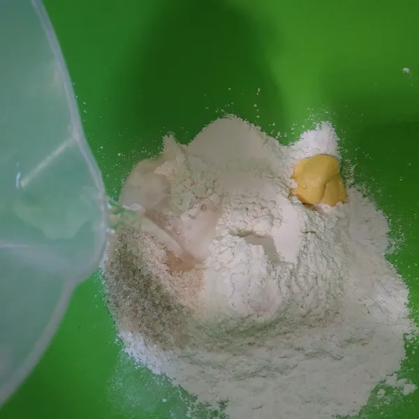 Campur tepung ketan, tepung terigu, margarin, garam, dan gula. Tuang air panas sedikit demi sedikit.