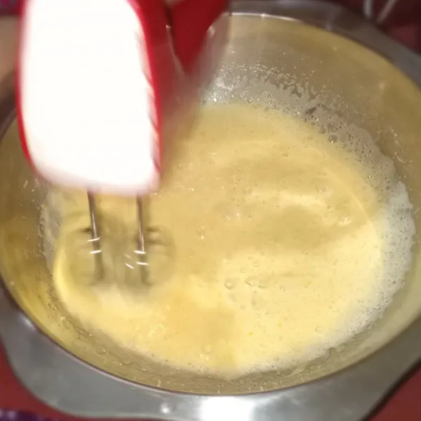 Mixer atau kocok telur dan gula pasir hingga berubah warna. Tambahkan susu bubuk, kocok hingga mengembang sempurna.