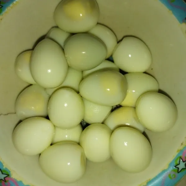 Setelah telur tidak terlalu panas, kupas cangkangnya dan bilas dengan air agar tidak ada kulit telur yang tersisa.
