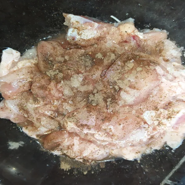 Siapkan daging ayam dalam mangkuk, lalu bumbui dengan lada hitam bubuk dan juga sedikit garam. Aduk hingga tercampur rata, lalu diamkan selama 15 menit agar bumbu meresap.