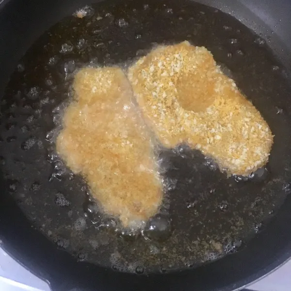 Goreng ayam katsu dalam minyak panas dan banyak hingga golden brown. Jangan kelamaan karena ayam akan alot, api sedang saja.