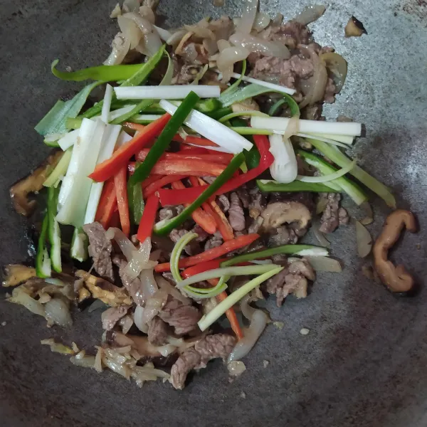 Masukkan irisan daun bawang, cabe merah, dan cabe hijau. Setelah layu, matikan apinya.