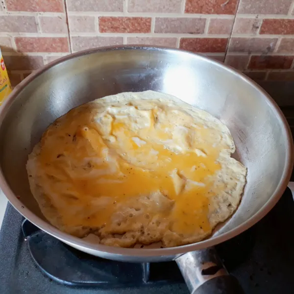 Kocok lepas telur, oregano dan kaldu dengan garpu. Dadar setengah telur.