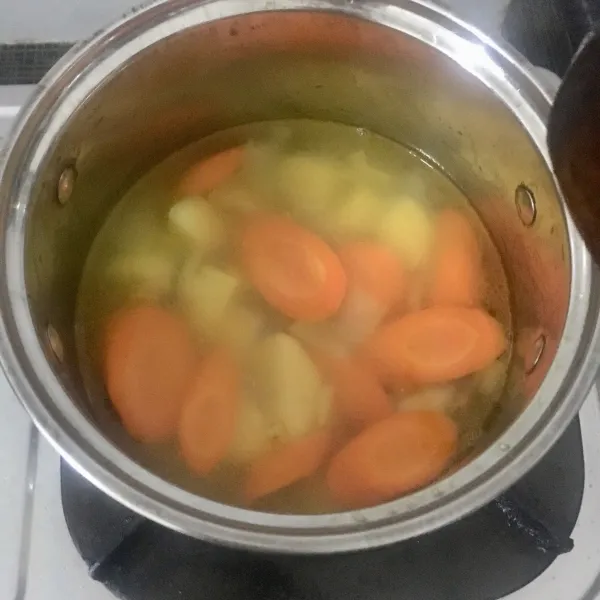 Masukkan air dan masak sampai wortel dan kentang matang.