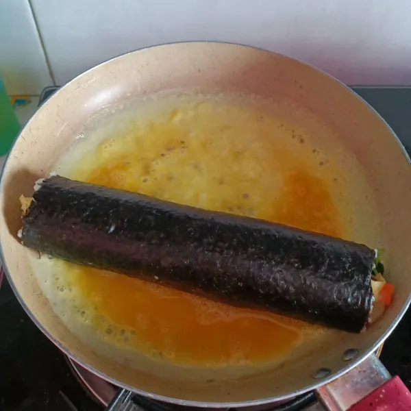 kocok lepas 2 butir telur, kemudian masukkan kedalam teflon anti lengket. Letakkan gimbab disalah satu sisinya.