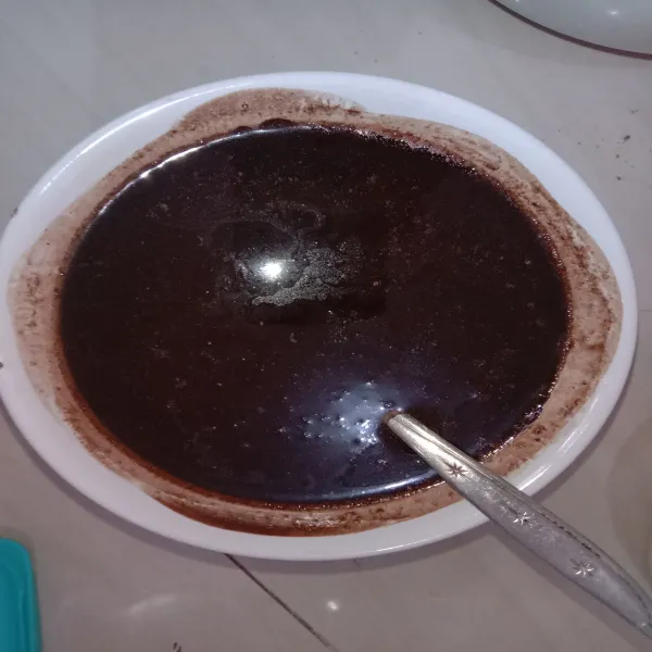Lelehkan mentega kemudian tuang ke dalam potongan coklat, aduk sampai coklat larut. Tambahkan minyak. Sisihkan.