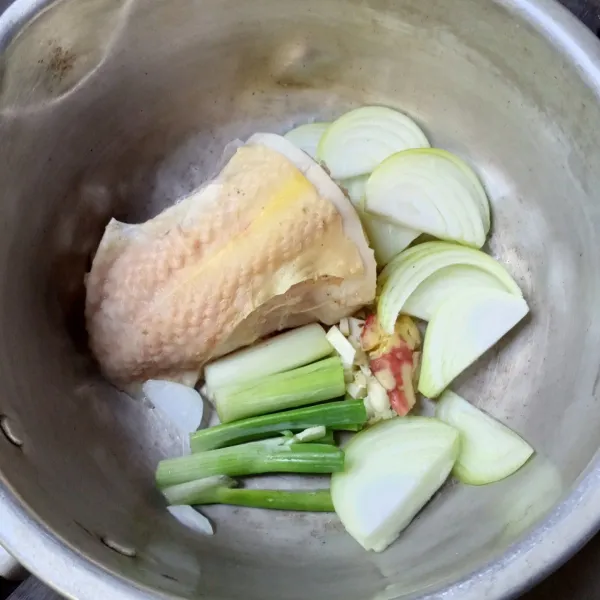 Masukkan ayam, daun bawang, bawang putih cincang, jahe geprek dan irisan bawang bombai.