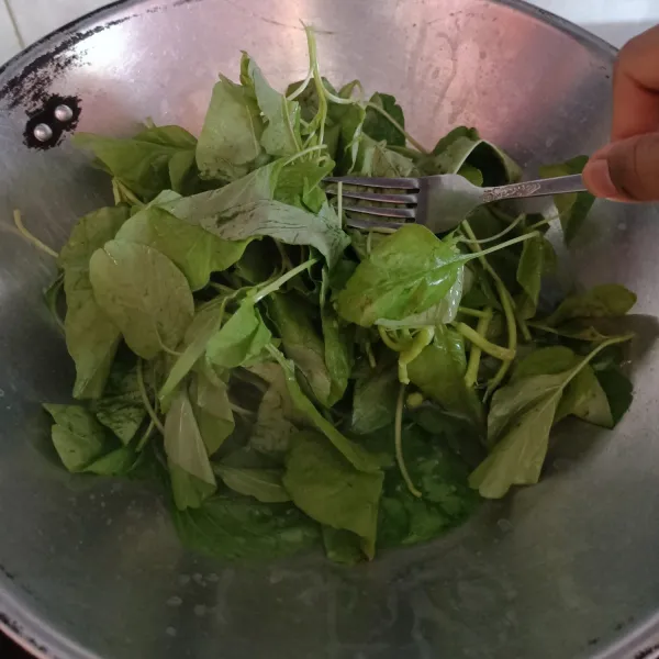 Petik bayam daunnya saja lalu rebus sampai setengah matang. Angkat dan beri sedikit minyak wijen, sisihkan.