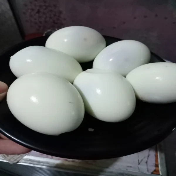 Rebus telur selama 20 menit, kemudian kupas cangkangnya.