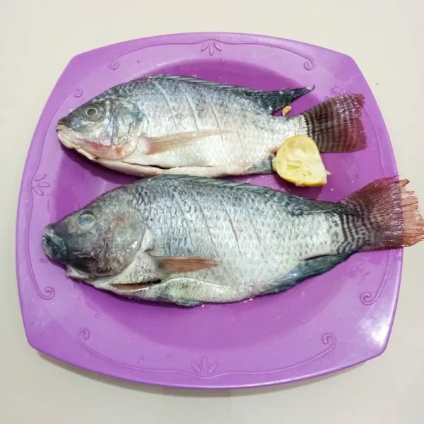 Bersihkan ikan nila dari sisik, isi perut dan insangnya. Cuci dan bilas hingga bersih. Kemudian lumuri dengan air jeruk nipis dan garam. Diamkan 10 menit agar meresap.