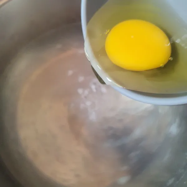 Masukkan telur saat air masih berputar membentuk lingkaran di tengah.