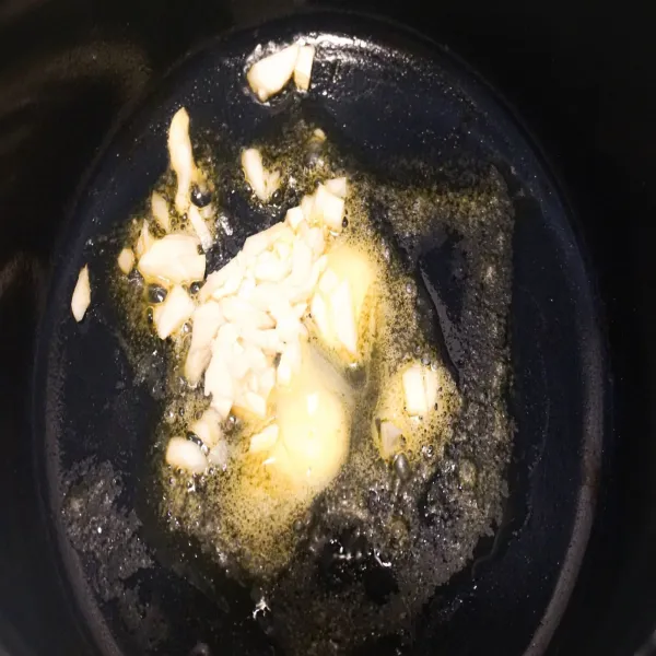 Tumis bawang putih ke dalam mentega yang telah panas.