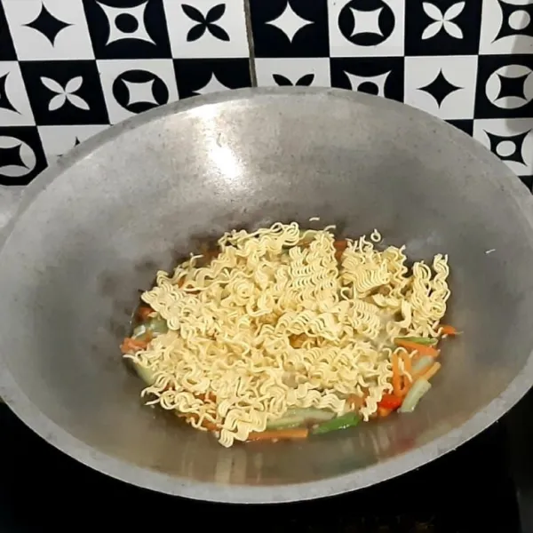 Masukkan mie instan. Rebus hingga mie matang dan air menyusut (bila setelah air menyusut mie belum juga matang, tambahkan lagi sedikit air mendidihnya).