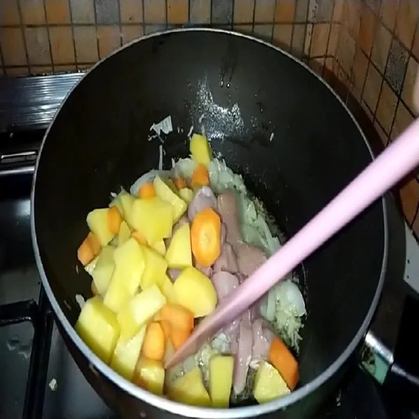 Masukkan ayam, kentang, dan wortel. Masak hingga ayam berubah warna.