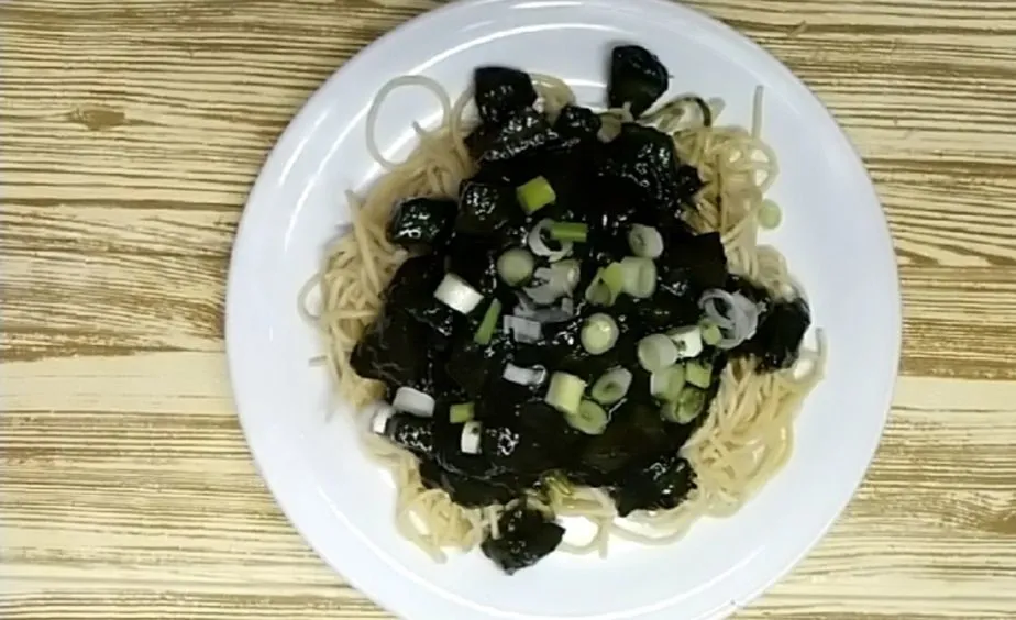 Tata spaghetti dalam piring, beri saus Jajangmyeon dan taburi dengan irisan daun bawang. Siap disajikan.