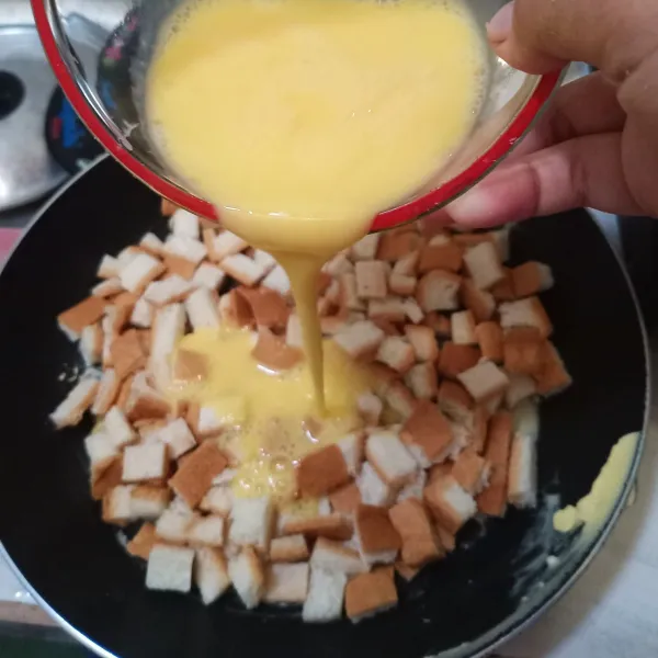 Tuangkan kocokan telur ke dalam pan, tunggu sampai rata dan agak ditekan-tekan.