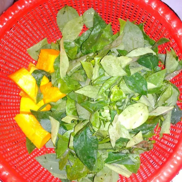 Siangi daun katuk dan potong-potong labu kuning, lalu cuci bersih.