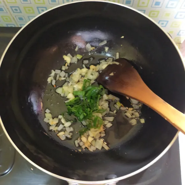 Panaskan 2 sdm minyak goreng untuk menumis. Masukkan bawang putih dan bawang bombay. Tumis sampai harum, lalu masukkan daun bawang.