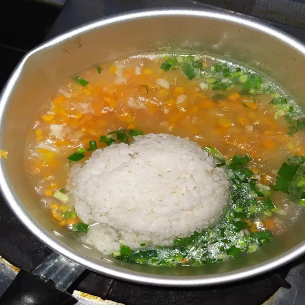 Masukkan juga nasi, aduk-aduk. Masak hingga nasi mengembang.