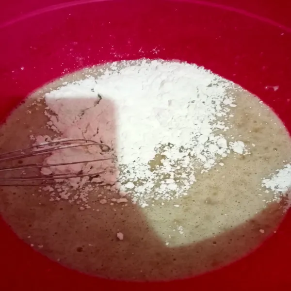 Masukkan tepung terigu sambil diayak lalu beri vanili bubuk dan garam, aduk merata.