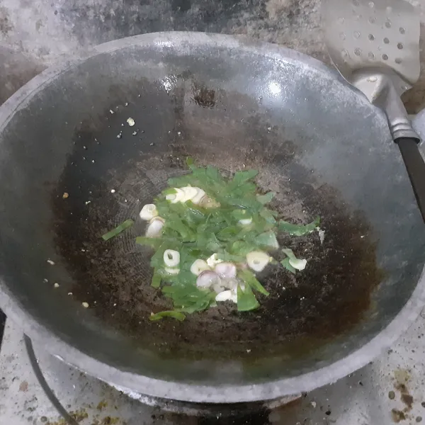 Rajang bawang merah, bawang putih dan daun bawang, tumis dalam sedikit minyak panas hingga harum.